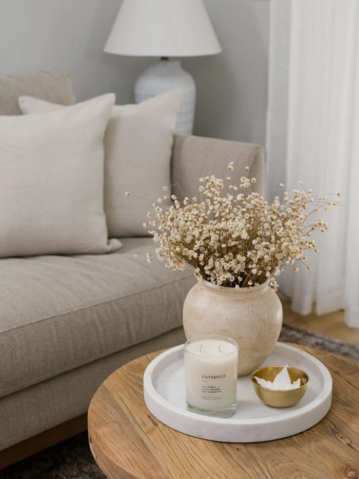 Some flowers in vase and a candle near it by interior designing company in malappuram