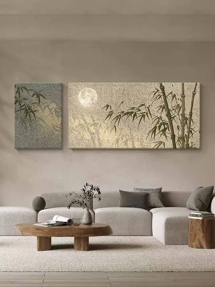 A modern living room featuring neutral-toned sofas, a wooden coffee table, wall art with bamboo, styled by an Interior Designing Company in Malappuram